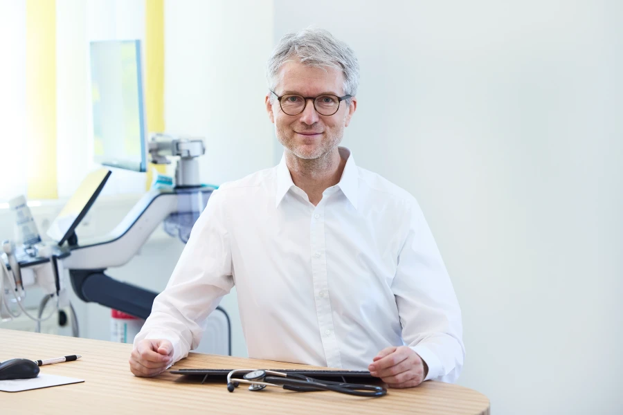 Prof. Dr. med. Peter Weyrich am Schreibtisch in seiner Praxis