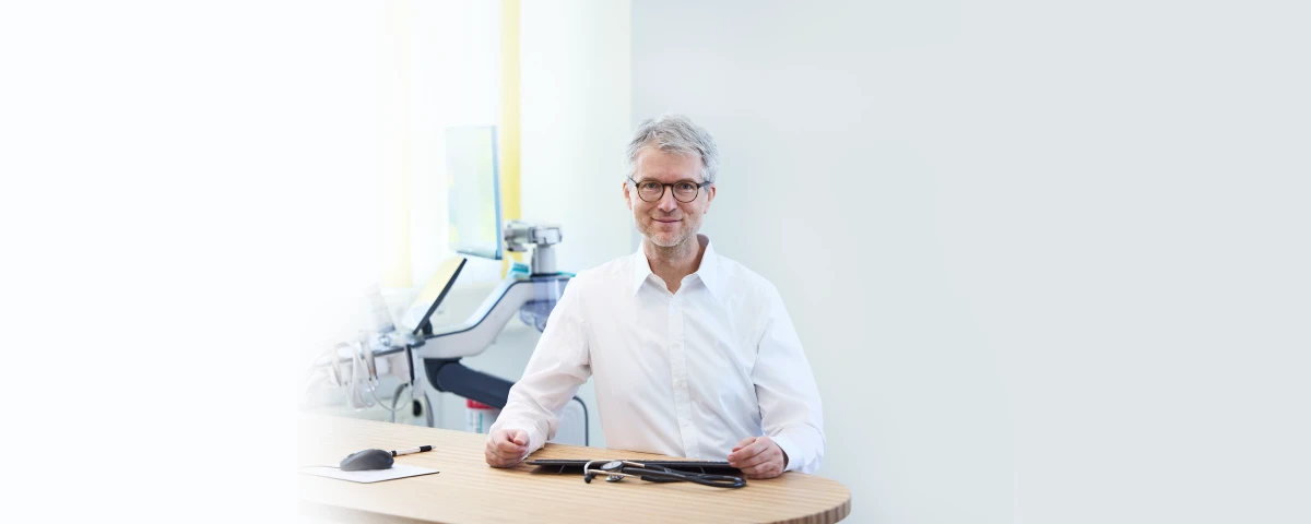 Prof. Dr. med. Peter Weyrich am Schreibtisch in seiner Praxis
